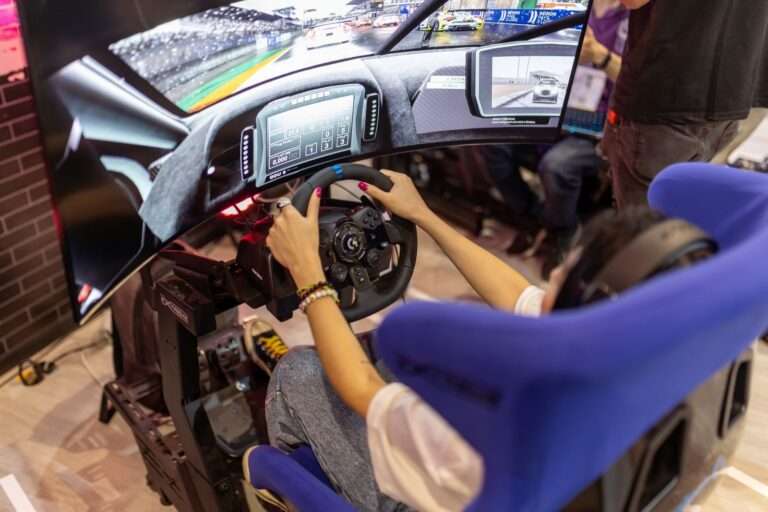 Person using a realistic VR racing simulator at a gaming event, focused on the immersive experience.